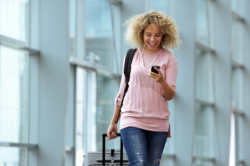 woman traveling in airport on her phone